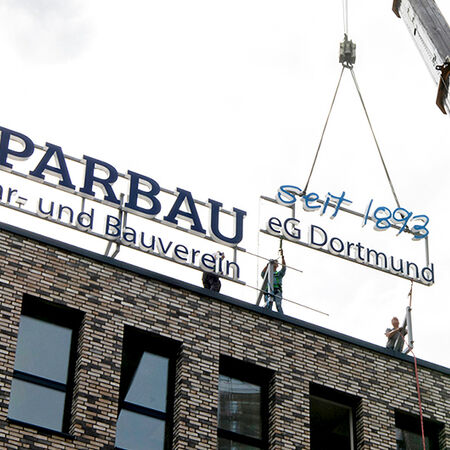 Leuchtschrift: Leuchtreklame — Dachkonstruktion Firmenschriftzug und Logo. Produziert von der Firma Visscher Lichtwerbung aus Dortmund.